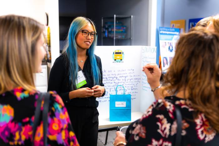 Photo of Route Rider student company representative talking with an attendee during the expo.